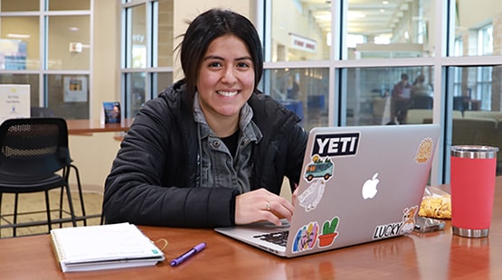 Student using laptop in campus space